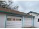 Spacious two-car garage featuring white doors with blue trim, offering ample parking and storage space at 5515 Zuni St, Denver, CO 80221