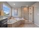 Bright bathroom featuring a soaking tub, glass-enclosed shower, and natural light at 15201 Yellowthroat St, Parker, CO 80134