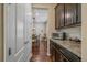 Hallway view showing a granite countertop, dark wood cabinets, and a glimpse of the adjacent dining area at 15201 Yellowthroat St, Parker, CO 80134