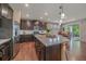 Well-lit kitchen featuring dark wood cabinets, stainless steel appliances, and a granite island with pendant lights at 15201 Yellowthroat St, Parker, CO 80134