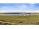 An aerial shot shows a lake in the distance beyond a grassy hill at 15201 Yellowthroat St, Parker, CO 80134