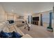 Comfortable living room with a white sectional sofa, plush carpeting, and a large screen television at 15201 Yellowthroat St, Parker, CO 80134