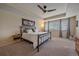 Spacious bedroom with a tray ceiling, ceiling fan, and large windows allowing natural light at 15201 Yellowthroat St, Parker, CO 80134