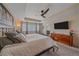 Well-lit bedroom showcasing a ceiling fan and an en suite bathroom at 15201 Yellowthroat St, Parker, CO 80134