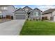 Gray exterior boasts a two-car garage and well-manicured lawn at 3037 Lake Helen Blvd, Mead, CO 80542