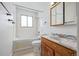 Bathroom features a tub-shower, wood vanity with cultured marble top, and a window at 5542 Sable St, Denver, CO 80239