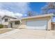 View of the well-maintained brick home, landscaped front yard, long driveway, and an attached two-car garage at 5542 Sable St, Denver, CO 80239