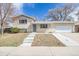 Charming exterior of this home showcasing a well-maintained yard, brick facade, driveway, and attached two-car garage at 5542 Sable St, Denver, CO 80239