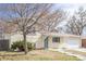 View of the well-maintained brick home, landscaped front yard, concrete steps, and a partial view of the driveway at 5542 Sable St, Denver, CO 80239