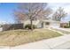 View of the well-maintained brick home, landscaped front yard, concrete steps, and a partial view of the driveway at 5542 Sable St, Denver, CO 80239