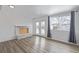 Living room showcasing wood floors, a fireplace, a large window, and access to the backyard at 5542 Sable St, Denver, CO 80239