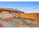 An open backyard is surrounded by a new wooden fence and an exterior of the home at 3690 N Hudson St, Denver, CO 80207