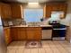 Cozy kitchen featuring wood cabinets, stainless steel appliances, and a window for natural light at 3690 N Hudson St, Denver, CO 80207