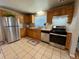 Functional kitchen featuring tiled floor, stainless steel appliances, and wood cabinets at 3690 N Hudson St, Denver, CO 80207