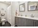 Well-lit bathroom with double sinks, gray cabinets, and decorative white subway tile backsplash at 7995 E Mississippi Ave # F23, Denver, CO 80247