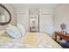 Bright bedroom featuring a decorative bedspread, a view to another doorway, and two closets at 7995 E Mississippi Ave # F23, Denver, CO 80247
