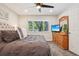 Bedroom featuring a ceiling fan, a window with green views, and a dresser with an accompanying mirror at 7995 E Mississippi Ave # F23, Denver, CO 80247