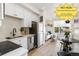 Bright kitchen featuring white cabinets, stainless steel appliances, and modern finishes open to living area at 5371 W 14Th Ave, Lakewood, CO 80214