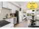 Modern kitchen with stainless appliances, white cabinets, stylish backsplash, and a view to the cozy living area at 5371 W 14Th Ave, Lakewood, CO 80214