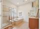 Bright bathroom features a walk-in shower, soaking tub, vanity, and tile flooring, offering a spa-like experience at 4553 Red Deer Trl, Broomfield, CO 80020
