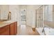 Bright bathroom featuring a walk-in shower, soaking tub, and a vanity with an adjacent doorway at 4553 Red Deer Trl, Broomfield, CO 80020