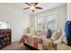 Cozy bedroom with natural light, ceiling fan, and a bed with a colorful, decorative quilt at 4553 Red Deer Trl, Broomfield, CO 80020