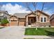 Charming single-Gathering home featuring a manicured lawn, stone accents, and an attached two-car garage at 4553 Red Deer Trl, Broomfield, CO 80020
