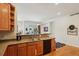 Kitchen bar with counter seating, wood cabinets, stainless steel appliances, and an open view into the living and dining areas at 4553 Red Deer Trl, Broomfield, CO 80020