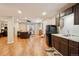Open-concept living area with a partial kitchen, comfortable seating, and hardwood floors, perfect for entertaining guests at 4553 Red Deer Trl, Broomfield, CO 80020
