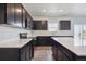 Modern kitchen featuring dark cabinetry, stainless steel appliances, and stylish countertops at 19059 E 94Th Pl, Commerce City, CO 80022