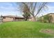 Large backyard offering ample green space, a covered patio, and mature shade trees at 865 S Everett St, Lakewood, CO 80226