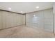 Well-lit basement area featuring neutral carpet, paneled walls, and overhead lighting at 865 S Everett St, Lakewood, CO 80226