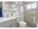 Modern bathroom with gray vanity, subway tile walls, and a glass-enclosed shower with wood-like tile at 865 S Everett St, Lakewood, CO 80226