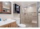 Tiled bathroom features shower with glass doors, sink with wood cabinet, and a dark wood medicine cabinet at 865 S Everett St, Lakewood, CO 80226