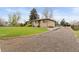 Charming exterior of home with gravel driveway, well-manicured lawn and mature landscaping at 865 S Everett St, Lakewood, CO 80226