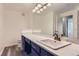 Bathroom vanity with a large mirror, modern lighting, and wood-look tile flooring at 7433 S Quail Cir # 1924, Littleton, CO 80127
