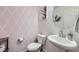 Charming powder room with patterned wallpaper, pedestal sink, and modern fixtures at 21613 E 59Th Pl, Aurora, CO 80019