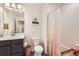 Bright bathroom with modern vanity, toilet, and shower featuring a decorative curtain adding charm to the space at 21613 E 59Th Pl, Aurora, CO 80019