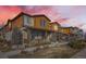 Attractive townhome exterior with a covered porch, stone accents, and well-maintained landscaping at 21613 E 59Th Pl, Aurora, CO 80019