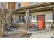 Charming front porch with a red door, decorative wreath, and cozy seating area, perfect for relaxing outdoors at 21613 E 59Th Pl, Aurora, CO 80019