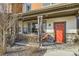 Inviting front porch with string lights, seating, and a vibrant red door with seasonal wreath at 21613 E 59Th Pl, Aurora, CO 80019