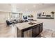 Open-concept kitchen featuring a large island, stainless steel appliances, and seamless flow to the living area at 21613 E 59Th Pl, Aurora, CO 80019