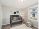 Cozy Bedroom with a grey crib, plush rug, and a decorative wall flowers at 3855 N Cook St, Denver, CO 80205