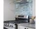 Modern kitchen with stainless steel oven and blue subway tile backsplash at 3855 N Cook St, Denver, CO 80205