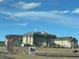 View of a large resort building complex set against a blue sky with scattered clouds, taken from the road at 5800 N Tower Rd # 404, Denver, CO 80249