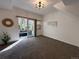 Bright, airy living room with neutral carpet, sliding glass doors to patio, and modern light fixture at 5800 N Tower Rd # 404, Denver, CO 80249