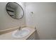 Clean bathroom with a round mirror and white vanity at 23541 E Portland Way, Aurora, CO 80016