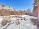 Snow-covered backyard with a partially visible stone retaining wall at 2066 S Rifle St, Aurora, CO 80013