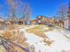 Side yard view of the house showing landscaping and snow at 2066 S Rifle St, Aurora, CO 80013