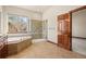 Well-lit bathroom with a soaking tub, glass enclosed shower, and large window at 26426 E Peakview Dr, Aurora, CO 80016